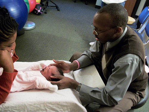 Chiropractor adjusting newborn